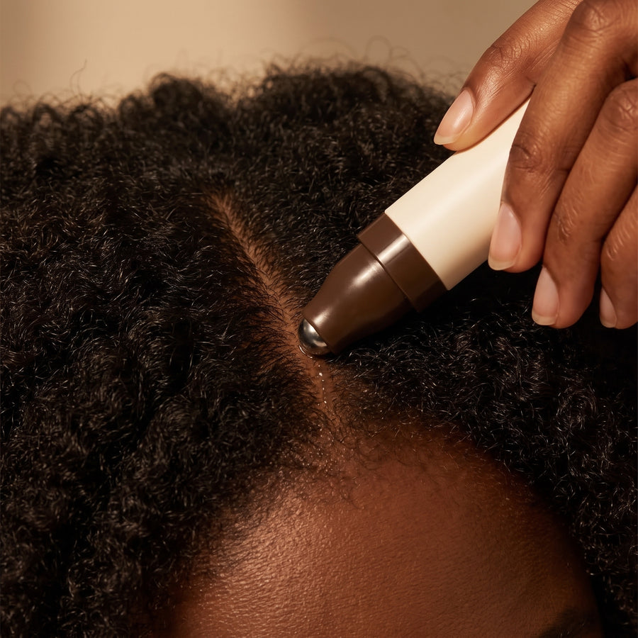 The rollerball tracing an exposed part line on the scalp
